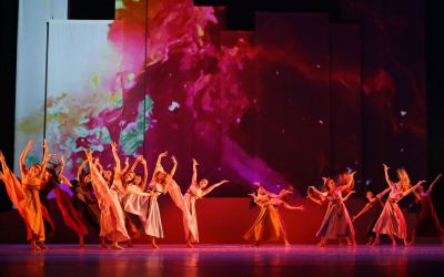 Scena zbiorowa - tańczący balet w strojach w różnych odcieniach różu. Młode baletnice mają uniesione wysoko nogi i ręce, część z nich ma też uniesione głowy, a ich włosy są rozwiane. W scenografii dominuje róż, fiolet, efekt rozmytych i połączonych ze sobą barw. 