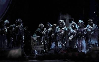 scena zbiorowa, w centrum wózek sklepowy wokół grupa artystów, czarne tło
